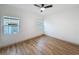 Unfurnished bedroom with hardwood floors and a ceiling fan, featuring ample natural light from two windows at 1267 Woodlawn Ter, Clearwater, FL 33755