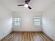 Unfurnished bedroom with hardwood floors and ceiling fan, featuring ample natural light from two windows at 1267 Woodlawn Ter, Clearwater, FL 33755