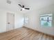 Unfurnished bedroom with hardwood floors, ceiling fan, natural light from two windows, and a closet door at 1267 Woodlawn Ter, Clearwater, FL 33755