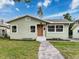 Charming single-story home features a stone walkway, light green siding, and a well-maintained front yard at 1267 Woodlawn Ter, Clearwater, FL 33755