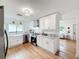 Bright kitchen featuring stainless steel appliances, white cabinets and light wood flooring and adjacent Living Room at 1267 Woodlawn Ter, Clearwater, FL 33755