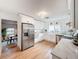 Bright kitchen featuring stainless steel appliances, white cabinets and light wood flooring and adjacent dining at 1267 Woodlawn Ter, Clearwater, FL 33755