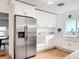 Bright kitchen featuring stainless steel appliances, white cabinets and a farmhouse sink and adjacent dining at 1267 Woodlawn Ter, Clearwater, FL 33755