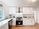 Modern kitchen with a stainless steel range hood, cooktop, and ample counter space at 1267 Woodlawn Ter, Clearwater, FL 33755
