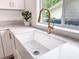Bright kitchen sink featuring gold fixtures and a marble countertop at 1267 Woodlawn Ter, Clearwater, FL 33755