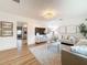 Bright living room with hardwood floors, stylish sofas, a TV, and a view into the kitchen at 1267 Woodlawn Ter, Clearwater, FL 33755