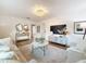 Bright living room featuring hardwood floors, stylish sofas, a TV, and access to other rooms at 1267 Woodlawn Ter, Clearwater, FL 33755