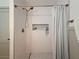 This shower features white tiling and a built-in niche for toiletries. The floors are a penny tile at 1267 Woodlawn Ter, Clearwater, FL 33755