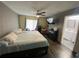 Cozy main bedroom with dark wood floors, ceiling fan and adjacent en-suite bathroom at 12912 Leadwood Dr, Riverview, FL 33579
