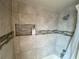 Close up on tiled shower with mosaic accents and a shower caddy inset at 12912 Leadwood Dr, Riverview, FL 33579