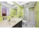 Bright bathroom featuring a walk-in shower, toilet, sink and vanity with an ample mirror at 13563 Cordova Dr, Largo, FL 33774