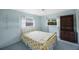 Comfortable bedroom with neutral carpet, updated ceiling fan, and ample natural light from large windows at 13563 Cordova Dr, Largo, FL 33774