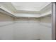 Walk-in closet with built in shelving and metal hanging bars, offering ample storage at 13563 Cordova Dr, Largo, FL 33774