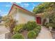 Inviting entrance with red door, mature landscaping, and a charming walkway at 13563 Cordova Dr, Largo, FL 33774