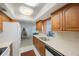 Functional kitchen with wooden cabinetry, white appliances, and view of adjacent living space at 13563 Cordova Dr, Largo, FL 33774