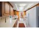 Efficient kitchen featuring wooden cabinets, white appliances, and view of dining area at 13563 Cordova Dr, Largo, FL 33774