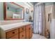 Bright bathroom featuring light blue walls, a wooden vanity and a large mirror at 14000 104Th Ave, Largo, FL 33774
