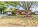 Charming single-story home featuring a well-manicured lawn, mature tree, and attached two-car garage at 14000 104Th Ave, Largo, FL 33774