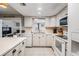 White kitchen with stainless steel appliances, tile flooring and view into den at 14000 104Th Ave, Largo, FL 33774