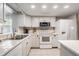 White kitchen featuring modern appliances, white cabinetry, and tile countertops at 14000 104Th Ave, Largo, FL 33774
