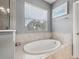 Bright bathroom featuring a luxurious soaking tub, natural light and neutral, stone-look ceramic tile at 1436 30Th N Ave, St Petersburg, FL 33704