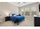 Cozy bedroom with a blue bedspread, natural light from the window, and carpeted floors at 1436 30Th N Ave, St Petersburg, FL 33704