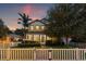 Inviting two-story home illuminated at twilight, showcasing a well-maintained lawn and classic architectural details at 1436 30Th N Ave, St Petersburg, FL 33704