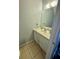 Half bathroom featuring vanity with white cabinet and sink, large mirror, and tile flooring at 144 Douglas W Rd # F, Oldsmar, FL 34677