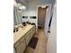 Bathroom with single vanity, mirror, and a glimpse of a toilet room at 144 Douglas W Rd # F, Oldsmar, FL 34677