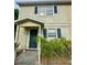 Two-story townhome featuring a covered entry and traditional windows with decorative shutters at 144 Douglas W Rd # F, Oldsmar, FL 34677
