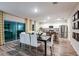 Open concept dining area with modern table, white chairs, and adjacent kitchen space at 14807 Summer Branch Dr, Lithia, FL 33547