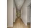 Long hallway with hardwood flooring and neutral paint leading to various rooms at 14815 Summer Branch Dr, Lithia, FL 33547