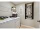 Bright laundry room with white appliances and a wire shelf for storage at 14815 Summer Branch Dr, Lithia, FL 33547