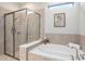 Bright bathroom featuring a soaking tub and a glass-enclosed shower at 1512 Banner Elk St, Valrico, FL 33594