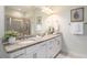 Bathroom featuring double vanity, granite countertops, framed mirrors, and a glass-enclosed shower at 1512 Banner Elk St, Valrico, FL 33594