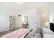 An inviting bedroom has a pink blanket with an adjacent desk and shelving at 1512 Banner Elk St, Valrico, FL 33594