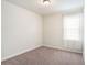 An empty bedroom with a window for light and carpeted floors at 1512 Banner Elk St, Valrico, FL 33594