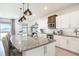 Bright kitchen boasting stainless steel appliances, white cabinets, a granite island, and modern pendant lighting at 1512 Banner Elk St, Valrico, FL 33594