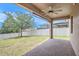 Covered outdoor patio features a ceiling fan, brick pavers, and backyard view at 1512 Banner Elk St, Valrico, FL 33594