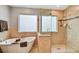 Bathroom featuring glass enclosed shower, soaking tub, and frosted windows for privacy at 160 Sage Cir, Crystal Beach, FL 34681