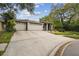 Exterior view of a home with a long driveway and a 2-car garage showcasing landscaping at 160 Sage Cir, Crystal Beach, FL 34681