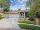 Charming home with a three-car garage, arched entrance, and colorful landscaping at 160 Sage Cir, Crystal Beach, FL 34681