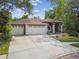 Charming home with a three-car garage, arched entrance, and lovely landscaping at 160 Sage Cir, Crystal Beach, FL 34681