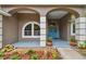 Close-up of a covered front porch with double doors, plants, and an arched window at 160 Sage Cir, Crystal Beach, FL 34681