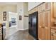 View of the kitchen with wood cabinets and black refrigerator, with a view to the living room at 160 Sage Cir, Crystal Beach, FL 34681