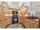 Charming kitchen featuring wood cabinets, black appliances, and tile flooring at 160 Sage Cir, Crystal Beach, FL 34681