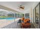 Relaxing screened-in patio with modern furniture, ceiling fan, and a view of the pool and lush landscaping at 160 Sage Cir, Crystal Beach, FL 34681