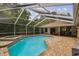 Inviting screened-in pool and spa with brick patio, perfect for relaxation and outdoor entertainment at 160 Sage Cir, Crystal Beach, FL 34681