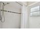 Clean shower features white tile with accent strip, handheld sprayer, and window at 160 Sage Cir, Crystal Beach, FL 34681