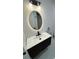 Modern bathroom features oval mirror with vanity, stylish fixtures, and under cabinet lighting at 1778 New Hampshire Ne Ave, St Petersburg, FL 33703